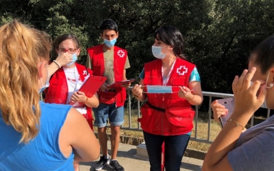 Voluntaris de Creu Roja Sabadell explicant a unes joves com funciona la mascareta | Cedida