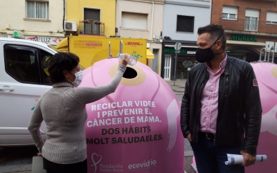 Marta Morell diposita una ampolla de vidre als nous contenidors acompanyada de Jesús Rodríguez