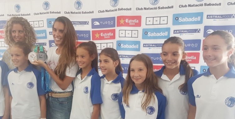 Ona Carbonell envoltada de nenes del seu campus i amb les dues medalles assolides a Hongria