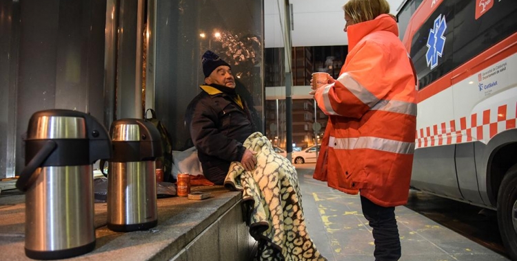 Un tècnic de Creu Roja atenent una persona que dorm al carrer | Roger Benet