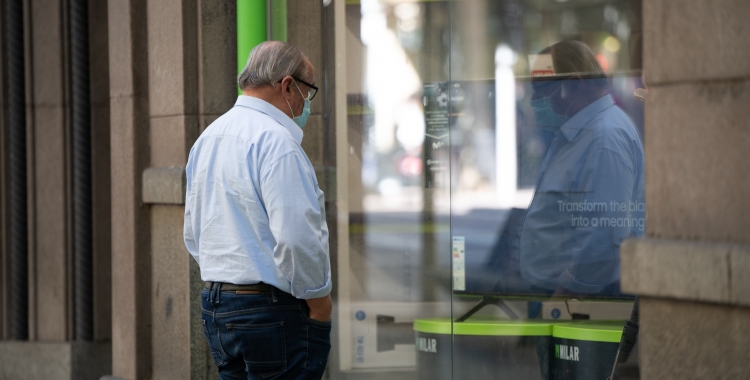 Un home contempla un aparador al centre de Sabadell | Roger Benet