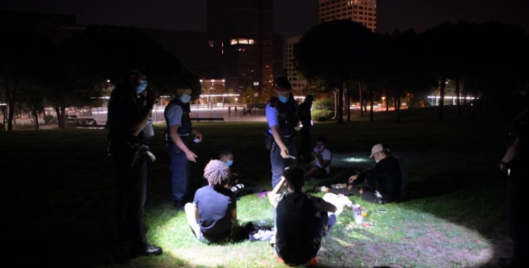 Agents de la policia expliquen a un grup de joves que està prohibit beure a la via pública