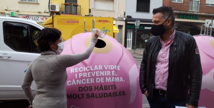 Marta Morell diposita una ampolla de vidre als nous contenidors acompanyada de Jesús Rodríguez