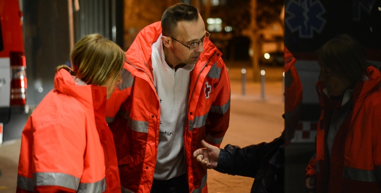 Voluntaris de Creu Roja parlen amb una persones sense llar al carrer | Roger Benet