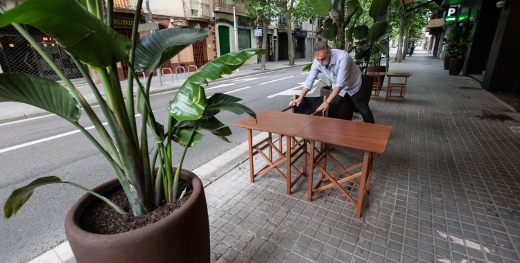 Un restaurador habilitant una terrassa a l'avinguda Onze de Setembre | Roger Benet