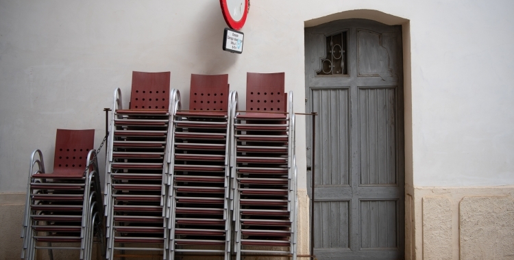 Cadires apilonades a les portes d'un bar tancat | Roger Benet