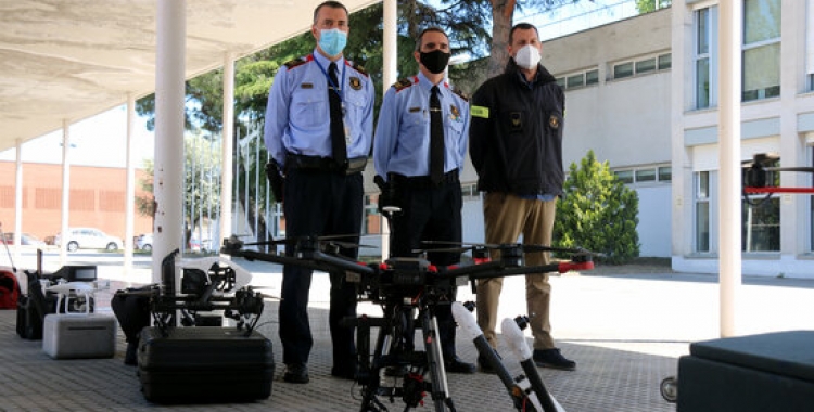 El cap de l'àrea de mitjans aeris, Avel·lí Garcia; el comissari portaveu, Joan Carles Molinero, i el sergent responsable de la unitat de drons antiga, davant alguns drons, el 13 de maig del 2021. (Horitzontal)