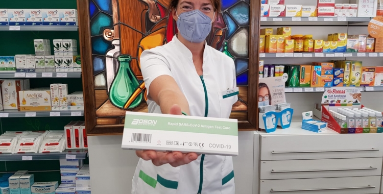 La farmacèutica Marta Gili mostrant un test d’autodiagnòstic de covid 