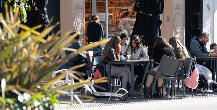 Unes noies prenent alguna cosa en una terrassa | Roger Benet