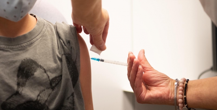 Un sanitari vacuna un nen contra la Covid-19 | Roger Benet