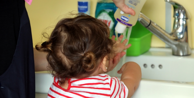 Una nena rentant-se les mans | ACN