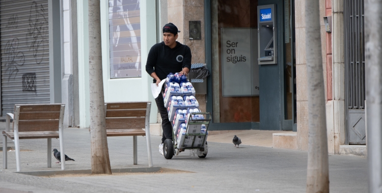 Un repartidor camina pel carrer | Roger Benet