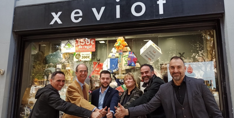 Els responsables de les diferents entitats col·laboradores davant de la panera a la botiga Xeviot | Pere Gallifa