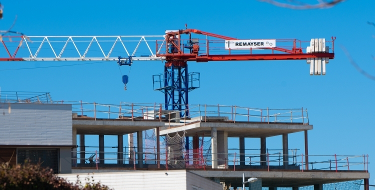 Una grua treballant en la construcció d'una promoció d'habitatges | Roger Benet