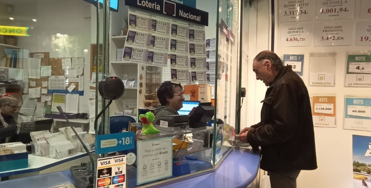 Un ciutadà comprant loteria a l'administració de la Via Massagué/ Karen Madrid