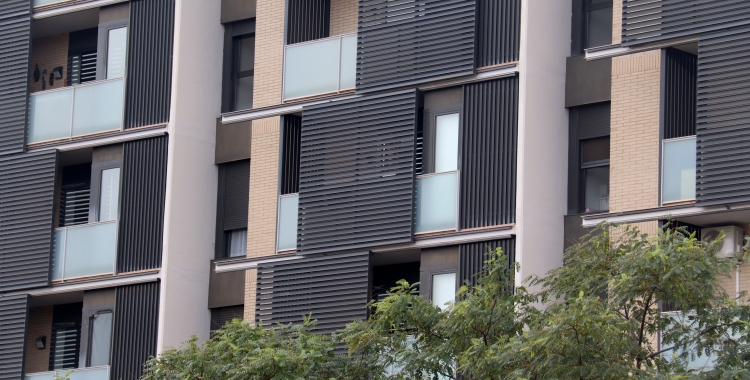 Un edifici de pisos amb la façana de color gris 