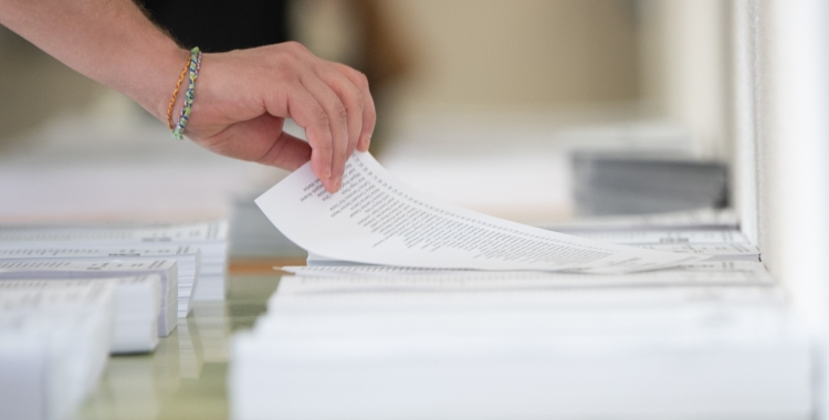 Un ciutadà agafant la papereta per votar a les eleccions de diumenge a Sabadell | Roger Benet