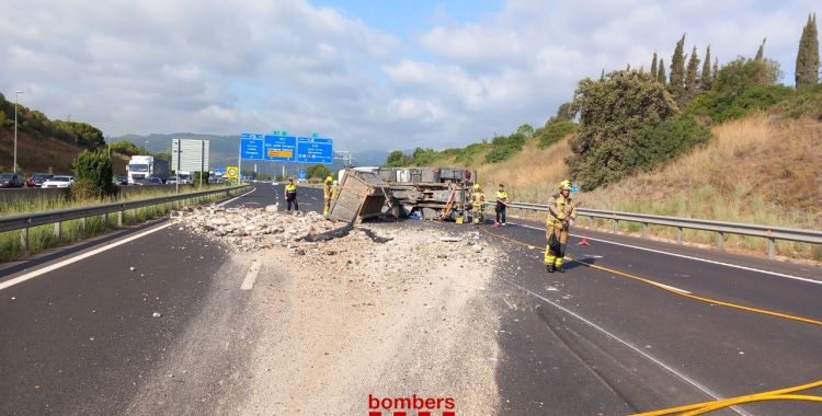 Els Bombers netegen l'AP7 després que un camió amb runa hagi bolcat