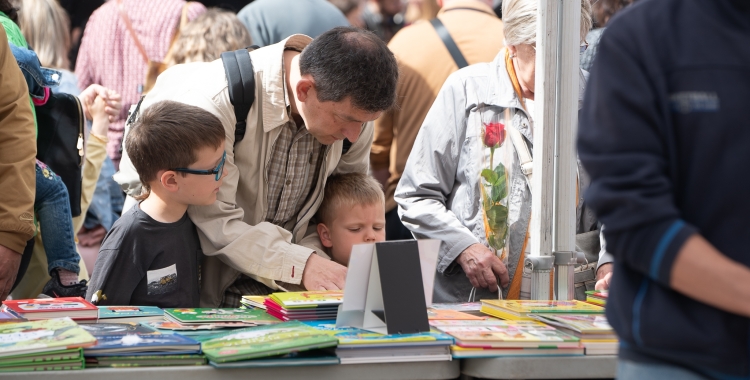 Un pare i un nen mirant llibres per Sant Jordi a Sabadell