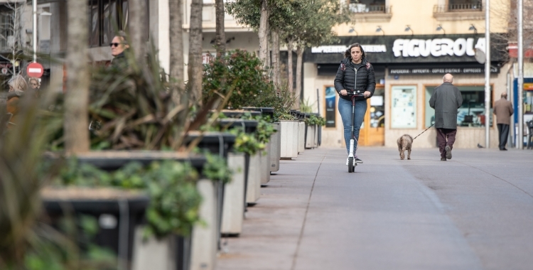 Noia anant amb patinet pel passeig de la plaça Major de Sabadell