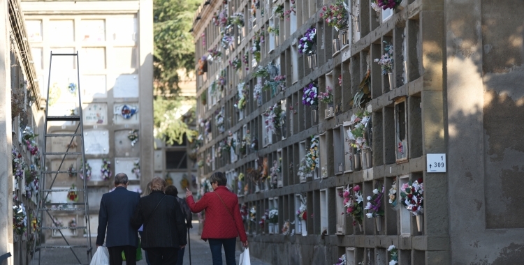 Tres persones caminant pel cementiri | Roger Benet