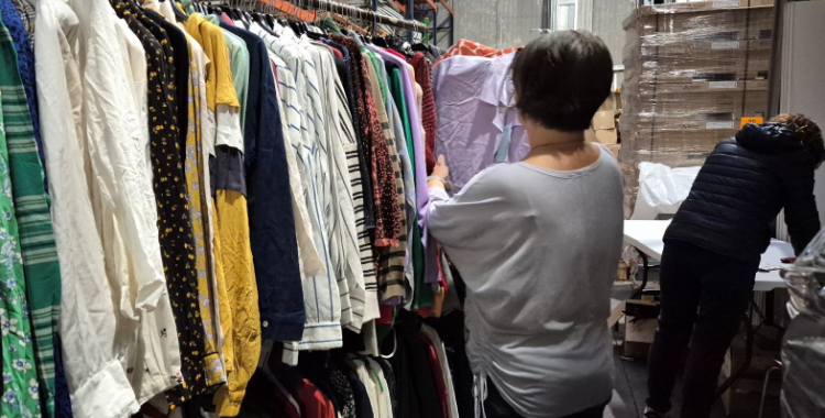 Diverses voluntàries preparant la roba que es posarà a la venda durant l'outlet