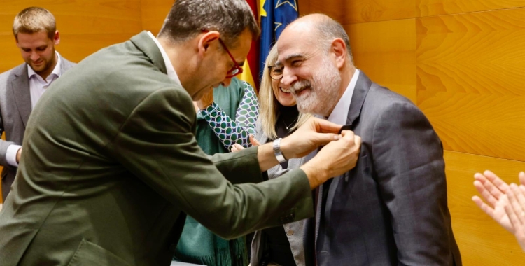 Ignasi Giménez col·locant el pin del Consell al nou president Xavier Garcés