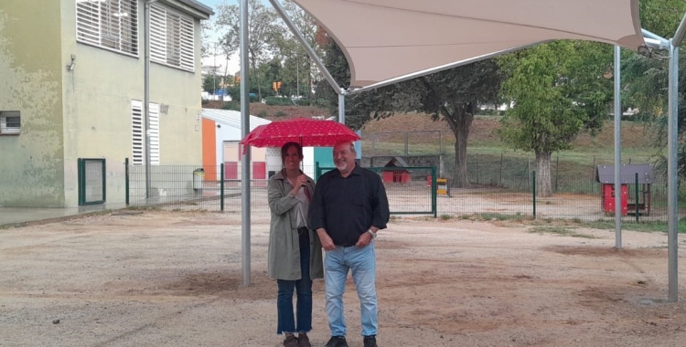 Marta Farrés i el regidor Manolo Robles sota el nou tendal instal·lat al pati de l'Escola Roureda