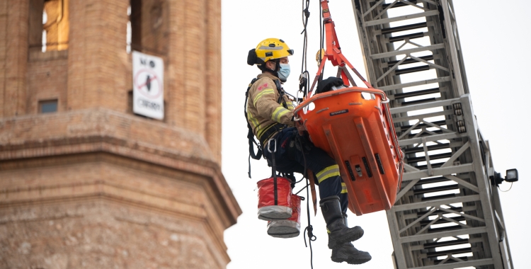 Un bomber fent un rescat amb l'autoescala