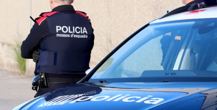 Un agent dels Mossos sobre un cotxe patrulla