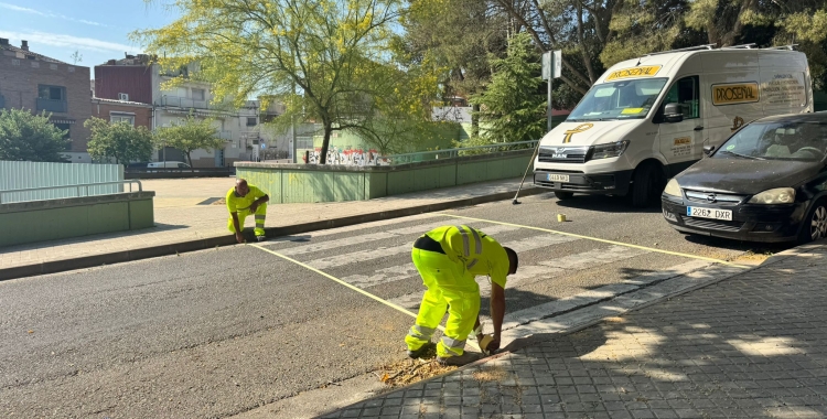 Treballadors pintant el zebrejat del carrer | Anna Clarà