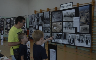 Un pare i dos nens miren les fotografies dels primers anys de l'escola. Foto: Ràdio Sabadell