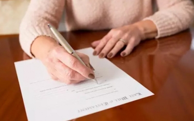 Una dona signant el Document de Voluntats Anticipades/Cedida