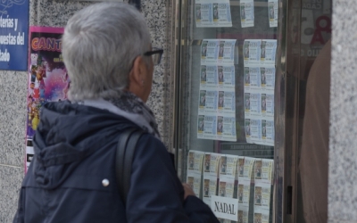 Una dona mira els dècims de loteria d'una administració | Roger Benet