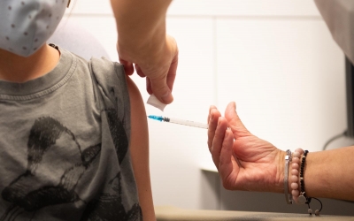 Un sanitari vacuna un nen contra la Covid-19 | Roger Benet