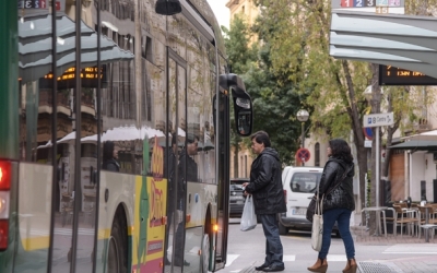 Un parell d'usuaris agafant un autobús de la TUS al carrer Sant Joan | Roger Benet