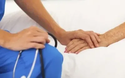Una infermera agafant la mà d'un pacient/ Cedida