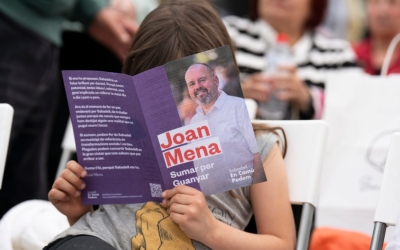 Un infant llegint propaganda electoral en un acte dels comuns | Oficial
