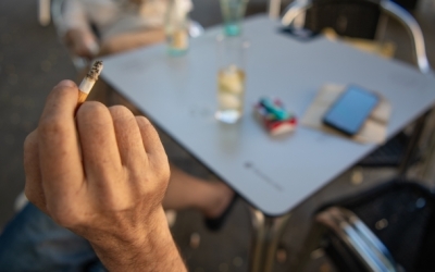Un client d'una terrassa amb una cigarreta a la mà