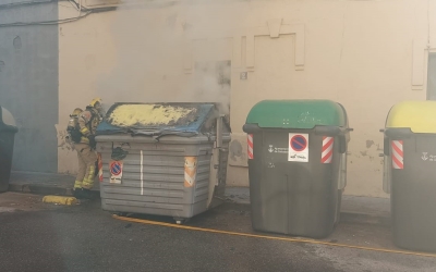 Un bomber apagant les flames d'un contenidor de paper 