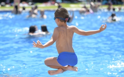 Un nen d'esquenes tirant-se a l'aigua
