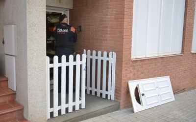 Un mosso a la porta de l'immoble que s'està escorcollant als Merinals | Roger Benet
