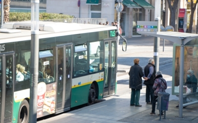 Gent en una parada d'autobús esperant | Arxiu