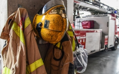 Uniforme de bomber en primer pla i camions al fons | Roger Benet