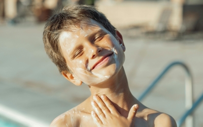 Un infant posant-se crema solar | Pexels