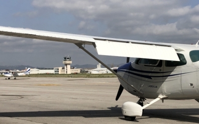 Un avió en primer pla amb la torre de control de l'Aeroport de fons