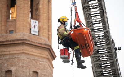 Un bomber fent un rescat amb l'autoescala