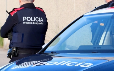 Un agent dels Mossos sobre un cotxe patrulla