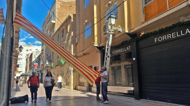 Instal·lació de les tradicionals senyeres al carrer Sant Antoni