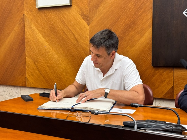 Didier Queloz firmant el llibre d'honor a l'ajuntament
